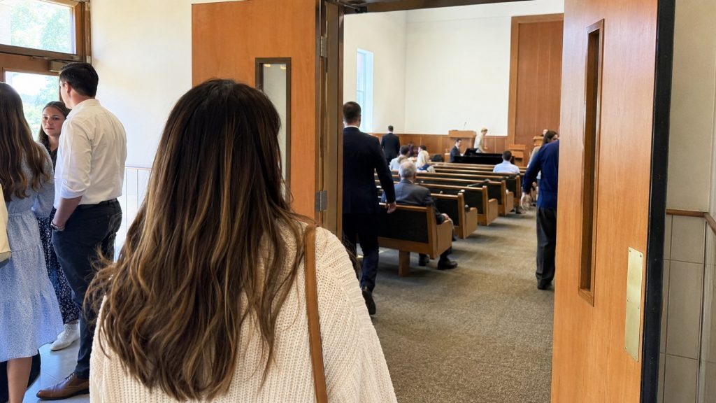 First-time visitor entering a Latter-day Saint chapel before Sunday worship