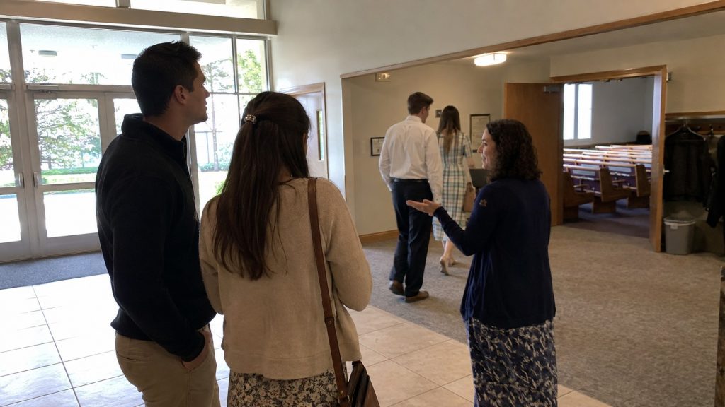 First-time visitors entering the foyer of a Latter-day Saint meetinghouse