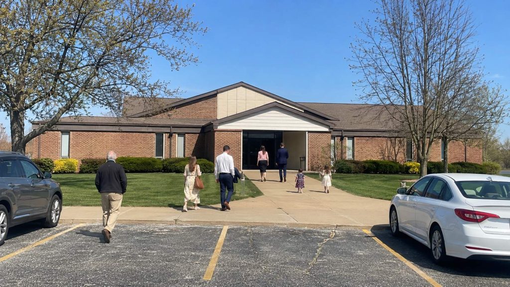 Latter-day Saint families arriving at a meetinghouse for Sunday worship