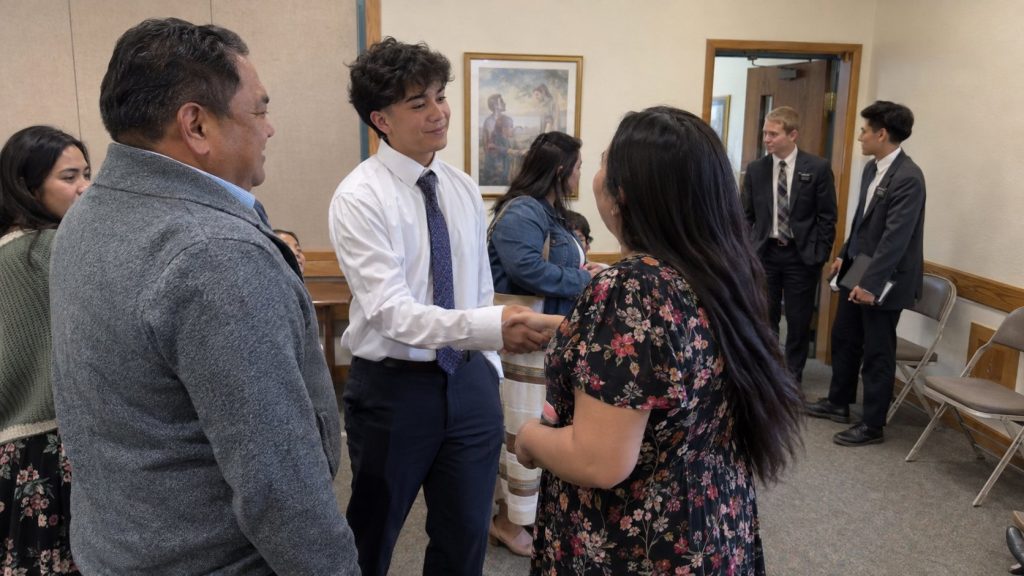 Family and friends congratulating someone after an LDS baptism