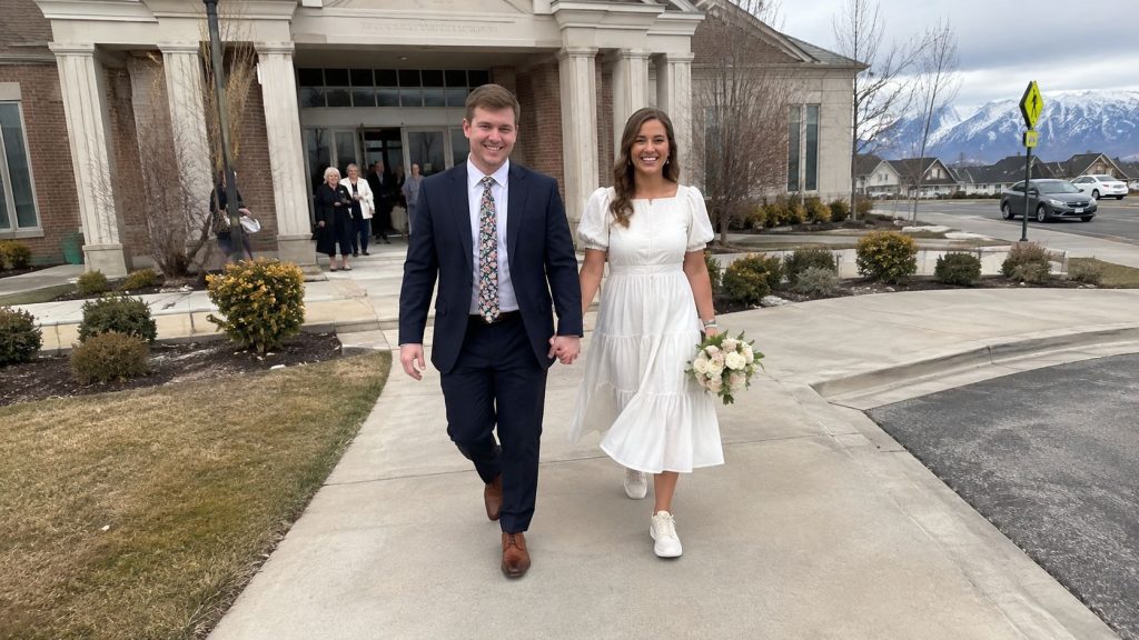 Newly married couple outside a Latter-day Saint meetinghouse after a civil wedding