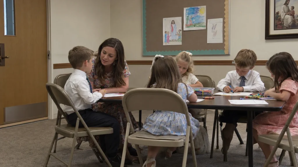A Primary teacher speaking calmly with a child during a Sunday class in a Latter-day Saint meetinghouse.